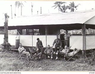 MADANG, NEW GUINEA. 1944-08-15. OFFICERS OF THE 165TH GENERAL TRANSPORT COMPANY RELAXING OUTSIDE THEIR MESS AFTER THE EVENING MEAL. IDENTIFIED PERSONNEL ARE:- NX59650 LIEUTENANT R.F. O'NEIL (1); ..