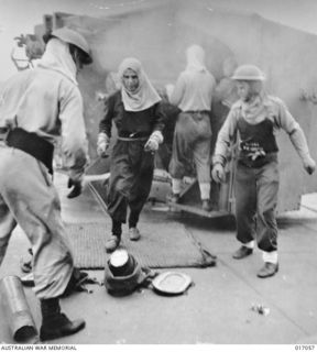 DUTCH NEW GUINEA. 1944-04. THE BIG GUNS OF AUSTRALIAN DESTROYER HMAS ARUNTA BLAZE AWAY AT JAPANESE VESSELS NEAR TANAHMERAH BAY IN DUTCH NEW GUINEA. THREE SUPPLY VESSELS WERE SUNK