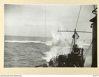 MADANG, NEW GUINEA. 1944-10-30. EXPLOSIONS CAUSED BY DEPTH CHARGES DURING A TRAINING EXERCISE ABOARD THE RAN SLOOP, SWAN