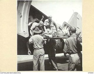 DREGER HARBOUR, NEW GUINEA. 1944-01. MEMBERS OF THE 10TH FIELD AMBULANCE LOADING PATIENTS ABOARD AN AIRCRAFT FOR EVACUATION AT THE STRIP A.D.S. DREGER HARBOUR (AIRSTRIP ADVANCED DRESSING STATION, ..