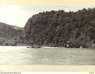 GNEISENAU POINT, NEW GUINEA. 1944-01-24. A SUBMERSIBLE JAPANESE OIL TANKER LYING BEACHED AT GNEISENAU POINT. THIS VIEW TAKEN FROM A PASSING LANDING CRAFT MECHANIZED SHOWS THE GORGE AND PART OF THE ..