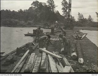 AITAPE, NORTH EAST NEW GUINEA. C. 1944-06. RAAF ENGINEERS SHARPENING JUNGLE LOGS TO BE USED AS PILES IN THE BUILDING OF A BRIDGE IN THE AITAPE AREA