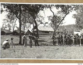 POM POM VALLEY, NEW GUINEA. 1943-11-27. VX117252 CAPTAIN G. H. NICHOLSON, OFFICER COMMANDING, MILITARY HISTORY SECTION DETAILING DRILL MOVEMENTS REQUIRED DURING THE TAKING OF A TRAINING FILM FOR ..