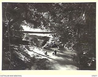 NORTH SAMPUN, NEW BRITAIN. 1945-01-15. TROOPS OF THE 14/32ND INFANTRY BATTALION WASHING THEIR CLOTHES IN THE MENSA RIVER
