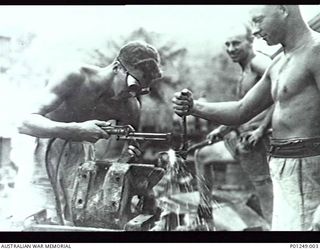 WARDS STRIP, PORT MORESBY, NEW GUINEA, 1943-03. RAAF FITTERS REPAIRING A PIECE OF EQUIPMENT WITH AN OXY-ACETYLENE WELDING TORCH. WARDS AERODROME WAS WORKED ON BY BOTH NO. 2 AND NO. 5 MOBILE WORKS ..