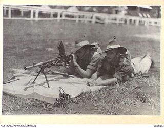 HERBERTON, QLD. 1945-01-19. PRIVATE L EATON (1) AND CORPORAL W A EVERETT (2), MEMBERS OF B COMPANY, 2/48TH INFANTRY BATTALION, COMPETING IN THE BREN LIGHT MACHINE GUN CONTEST