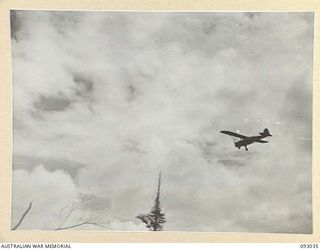 BOUGAINVILLE, 1945-06-08. AN RAAF AUSTER AIRCRAFT DROPPING THE DISPATCH RIDER LETTER SERVICE TO 2/8 COMMANDO SQUADRON TROOPS