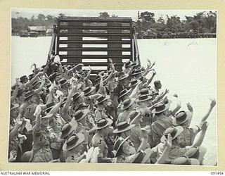 LAE, NEW GUINEA, 1945-05-07. HEADING FOR THE SHORE, AUSTRALIAN WOMEN'S ARMY SERVICE WAVE FROM THE LANDING BARGE TO THEIR SHIPMATES STILL ABOARD THE MV DUNTROON. THEY ARE PART OF A GROUP OF 342 ..
