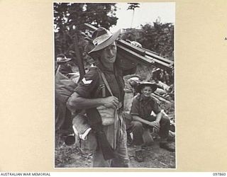 BORAM BEACH, NEW GUINEA. 1945-10-13. THE FIRST BATCH OF TROOPS TO LEAVE THE WEWAK AREA UNDER THE PRIORITY DEMOBILISATION SCHEME WERE MEMBERS OF 6 DIVISION. SHOWN LOADED WITH GEAR IS CORPORAL W. ..