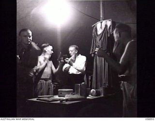 KONEDOBU (KANEDABU), NEW GUINEA. 1943-10-27. MEMBERS OF THE 7TH AUSTRALIAN DIVISION CONCERT PARTY MAKING UP IN THEIR TENT BEFORE THE SHOW. LEFT TO RIGHT: QX11740 PRIVATE J. J. GARNER; WX8193 GUNNER ..