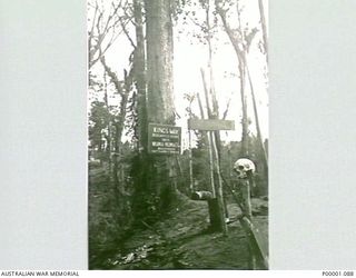 THE SOLOMON ISLANDS, 1945. SIGNPOST WITH A GRIM ACCOMPANIMENT BESIDE THE NUMA NUMA TRAIL ON BOUGAINVILLE ISLAND. (RNZAF OFFICIAL PHOTOGRAPH.)