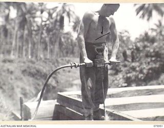 NAGADA, NEW GUINEA. 1944-09-11. N51443 SAPPER A. SELLARS, 5TH FIELD COMPANY, OPERATING A MULTIVANE 3/4" WOOD DRILL DURING THE CONSTRUCTION OF A BRIDGE ACROSS THE NAGADA RIVER