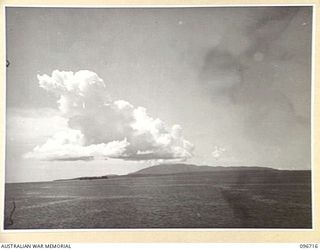 WEWAK POINT, NEW GUINEA, 1945-09-19.KAIRIRU ISLAND VIEWED FROM WEWAK POINT. THE MOUNTAINOUS TERRAIN OF KAIRIRU ISLAND MAKES MUSCHU ISLAND, WHICH LIES IN FRONT OF IT, ALMOST INDISCERNABLE. THE ..