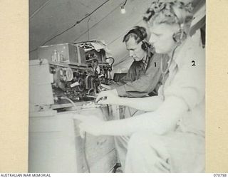 WAMPIT, NEW GUINEA. 1944-03-01. NX118908 TROOPER W. GEHRIG (1) AND NX127709 LANCE-CORPORAL WINTER (2), SIGNALLERS OF THE 9TH FIELD COMPANY, ROYAL AUSTRALIAN ENGINEERS, OPERATING A WIRELESS ..