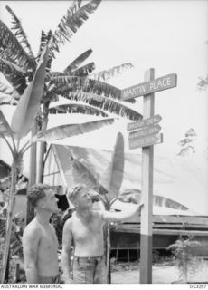 TOROKINA, BOUGAINVILLE ISLAND, SOLOMON ISLANDS. 1945-08-25. A SIGNPOST ERECTED BY MEMBERS OF NO. 7 AIRFIELD CONSTRUCTION SQUADRON RAAF IN THEIR CAMP. SHOWN: 4482 FLIGHT SERGEANT JIM BAIRD, NORWOOD, ..