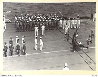 AT SEA OFF RABAUL, NEW BRITAIN. 1945-09-06. THE SURRENDER CEREMONY ON BOARD THE AIRCRAFT CARRIER HMS GLORY. LIEUTENANT GENERAL V.A.H. STURDEE, GENERAL OFFICER COMMANDING FIRST ARMY READS SURRENDER ..