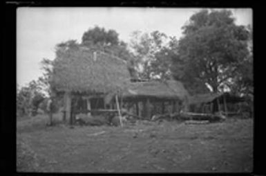 [Servicemen with thatched-roof structure]