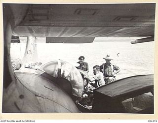 TOL, NEW BRITAIN. 1945-07-26. PERSONNEL AND MAIL LEAVING AN ROYAL NEW ZEALAND AIR FORCE SEACATS CATALINA TO GO TO TOL PLANTATION BY LAUNCH