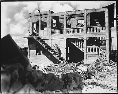 A Marine from the Third Marine Division goes after a sniper in a shelled building. Guam, August 1944.