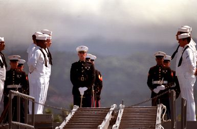 A Marine Corps honor guard stand aboard the frigate USS BREWTON (FF 1086) as a ceremony takes place to honor the Unknown Serviceman of the Vietnam Era. The serviceman's casket will be transported by ship to Alameda, California, and then transferred to Arlington National Cemetery for interment at the Tomb of the Unknowns