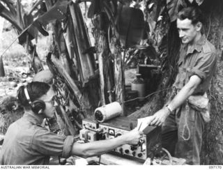 PILA PILA, RABAUL, NEW BRITAIN. 1945-09-25. SIGNALMAN L.S. LAZARUS (1) AND SIGNALMAN W. WATSON (2), MEMBERS OF 4 INFANTRY BRIGADE SIGNAL SECTION, 11 DIVISION SIGNALS, WORKING A NUMBER 10 WIRELESS ..