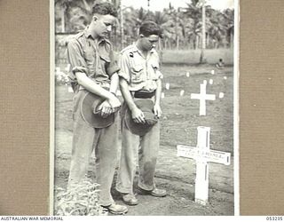 MILNE BAY, NEW GUINEA. 1943-06-26. NX103317 CORPORAL K.W. HODGETTS (LEFT) AND QX43558 CORPORAL R. BRITTAIN OF THE 8TH AUSTRALIAN ARMY MALARIAL CONTROL UNIT, AT THE GRAVE OF THEIR FRIEND, Q11879 ..