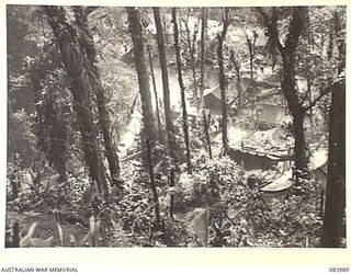 BOUGAINVILLE, SOLOMON ISLANDS, 1944-12-13. THE HEADQUARTER COMPANY COOKHOUSE, OF THE 9TH AUSTRALIAN INFANTRY BATTALION, SITUATED ON THE LEFT BANK OF THE LARUMA RIVER AS VIEWED FROM THE PIATERAPAIA ..