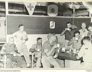 LAE, NEW GUINEA. 1944-11-18. NON COMMISSIONED OFFICERS OF THE 18TH FIELD AMBULANCE ENJOYING THEIR MORNING TEA THEIR AIRY AND WELL KEPT MESS. IDENTIFIED PERSONNEL ARE:- SERGEANT J. MALYON (1); LANCE ..