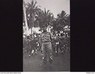 BOUGAINVILLE, C. 1945. CAPTAIN JOHN HAMILTON, VC, 30TH EMPLOYMENT COMPANY, 5TH WORKS COMPANY, WITH A GROUP OF NATIVES IN THE BACKGROUND. (DONOR A. HAMILTON)