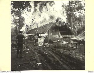 KILIGIA, NEW GUINEA. 1944-04-15. AN OUTBREAK OF FIRE IN THE SALVATION ARMY RECREATION HUT AT HEADQUARTERS 5TH DIVISION WHICH LEFT THE HUT A SMOKING RUIN WITHIN 4 1/2 MINUTES. DESPITE THE RAPID ..