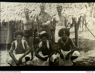 Buna, Papua. 1943-12-25. Group portrait of three members of 17 Field Hygiene Company with three indigenous (native) Papuans. Left to right: back row: K. Munro (possibly), A. Salmon who is holding a ..