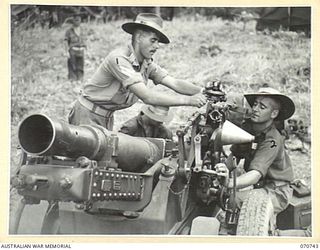 DALLMAN RIVER, NEW GUINEA, 1944-02-23. MEMBERS OF THE 2/14TH FIELD REGIMENT ADJUSTING THE DIAL-SIGHT ON A SHORT 25 POUNDER GUN. IDENTIFIED PERSONNEL ARE: VX81265 BOMBARDIER C.D. CHALMERS (1); ..