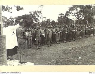 DUMPU, NEW GUINEA. 1944-02-06. SX1476 CHAPLAIN D.L. REDDING, (CHURCH OF ENGLAND) (1) AND VX39632 CHAPLAIN F.J. HARTLEY, (METHODIST) (2) JOINTLY CONDUCTING THE DEDICATION SERVICE AT THE DUMPU WAR ..