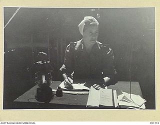 TOROKINA, BOUGAINVILLE. 1945-04-20. SISTER M. WALL, NIGHT SISTER, AUSTRALIAN ARMY NURSING SERVICE, 2/1 GENERAL HOSPITAL AT HER DESK