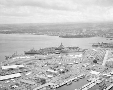 An aerial view of the aircraft carrier USS RANGER (CV 61) and other ships moored to piers during Exercise RIMPAC '86