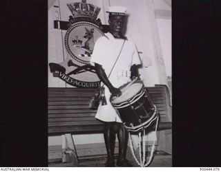 ADMIRALTY ISLAND 1955. ABLE SEAMAN LAISA KATMANA OF THE PNG DIVISION OF THE RAN WITH HIS DRUM AND BUGLE ON HMAS MELBOURNE DURING PASSAGE FROM HMAS TARANGAU, THE RAN SHORE STATION ON MANUS ISLAND. ..