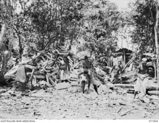 LAE, NEW GUINEA. 1944-03-30. NATIVE BOYS CHOPPING WOOD FOR THE BAKERY AT THE BAKERY 8TH FIELD BAKING PLATOON