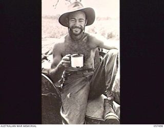 NADZAB, NEW GUINEA. 1943-09-20. VX1917 PRIVATE A. C. HANIFAN OF THE 2/153RD AUSTRALIAN GENERAL TRANSPORT COMPANY, ENJOYING A CUP OF COCOA AT NO. 1 AIRSTRIP