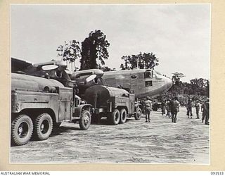 TOROKINA, BOUGAINVILLE. 1945-07-03. PETROL WAGONS REFUELLING AN AVRO YORK AIRCRAFT, THE ENDEAVOUR. THIS AIRCRAFT CARRIED HIS ROYAL HIGHNESS, THE DUKE OF GLOUCESTER, GOVERNOR-GENERAL OF AUSTRALIA, ..