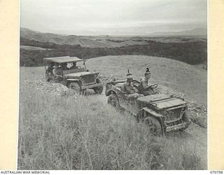 WAU - LAE ROAD, NEW GUINEA, 1944-03-03. QX34507 LIEUTENANT COLONEL W.J. REINHOLD, OBE, MC, COMMANDER ROYAL ENGINEERS, (A.I.F.) (1), AT THE MARKHAM VALLEY WITH HIS DRIVER NX137962 SAPPER R. PATRICK ..