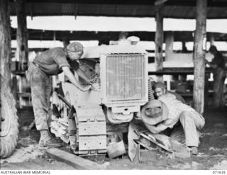LAE, NEW GUINEA. 1944-03-24. N157081 CRAFTSMAN (CFN) J. C. PROCTOR (1) WITH SX15529 CFN R. J. DOUGLAS (2), AND QX8864 CFN R. PRATTEN (3), WORKING ON AN ALLIS-CHALMERS TRACTOR AT THE 2ND MECHANICAL ..