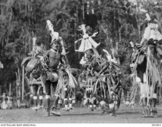 TOROKINA, BOUGAINVILLE. 1945-06-10. NATIVE SING-SING AT THE WEBB ROAD COMPOUND ON THE NUMA NUMA TRAIL WHICH WAS ATTENDED BY A LARGE NUMBER OF TROOPS. THE NATIVES PARTICIPATING ARE ATTACHED TO ..