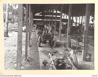 PALMALMAL PLANTATION, JACQUINOT BAY, NEW BRITAIN, 1945-06-06. PERSONNEL OF 1 INFANTRY TROOPS WORKSHOP AT WORK ON THE 'WILLOW RUN', AN ASSEMBLY LINE WHERE OLD VEHICLES ARE BROKEN DOWN AND RE-BUILT ..