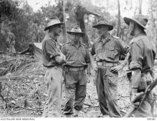 BOUGAINVILLE. 1945-04-06. LIEUTENANT COLONEL J.G. MCKINNA, COMMANDING OFFICER, 25 INFANTRY BATTALION (3), WITH SENIOR OFFICERS VIEWING THE SCENE OF ACTION ON SLATER'S KNOLL. IDENTIFIED PERSONNEL ..