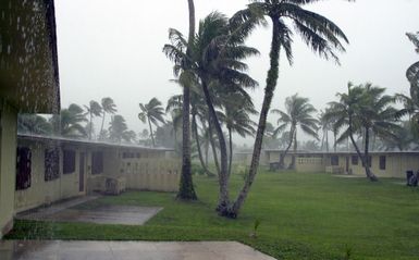 A view of the housing area at Andersen Air Force Base (AFB), showing the effects of the winds and rain in the forefront of Typhoon Chata'an. The typhoon created peak gusts of 104 miles per hour (mph), which scattered debris and trees causing damage to buildings, houses, and vehicles