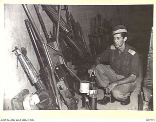 RABAUL, NEW BRITAIN. 1945-10-04. MEMBERS OF 33 FIELD SECURITY SECTION, 11 DIVISION, IN A CAVE NEAR DIVISIONAL HEADQUARTERS, WITH JAPANESE EQUIPMENT COLLECTED FOR MILITARY HISTORY SECTION