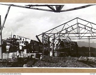 SALAMUA, NEW GUINEA. 1943-09-20. NATIVE LABOURERS FROM THE AUSTRALIAN NEW GUINEA ADMINISTRATIVE UNIT CLEANING UP DEBRIS AND WRECKAGE OF BOMB DAMAGED BUILDINGS ON THE ISTHMUS