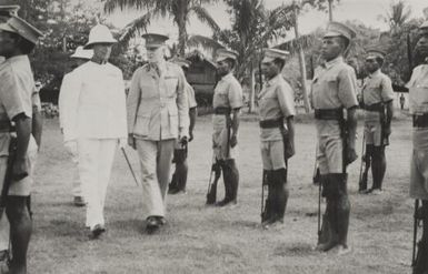 General Walter McNicoll reviews troops in New Guinea : he was knighted half way through his term of office there