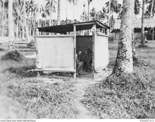 Madang, New Guinea, 1945-09-15. A well-constructed latrine or dunny at Headquarters, RAAF Northern Command (NORCOM). The latrine consists of a timber frame with hessian walls and a corrugated iron ..