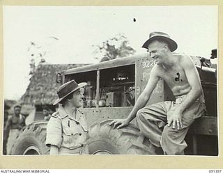 LAE, NEW GUINEA, 1945-05-06. LIEUTENANT-COLONEL M.J. SPENCER, ASSISTANT CONTROLLER OF AUSTRALIAN WOMEN'S ARMY SERVICE (1), SPEAKING TO SAPPER H.L. WILSON (2), DRIVER OF A GRADER WORKING IN THE ..